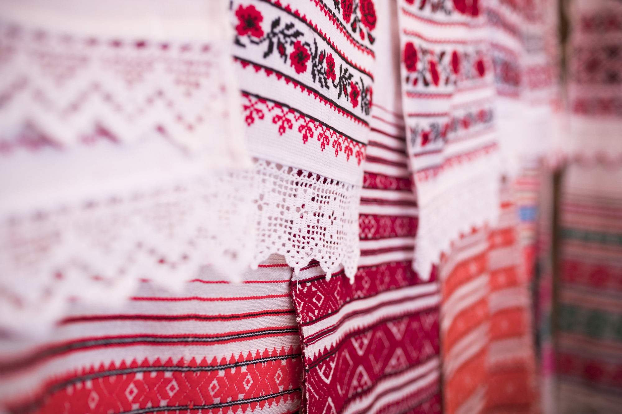 Tkane i haftowane białoruskie ręczniki obrzędowe. Wiszą na ścianie stoiska twórczyni. Wzory na ręcznikach są biało-czerwono-czarne. Niektóre zakończone doszytą białą koronką szydełkową.